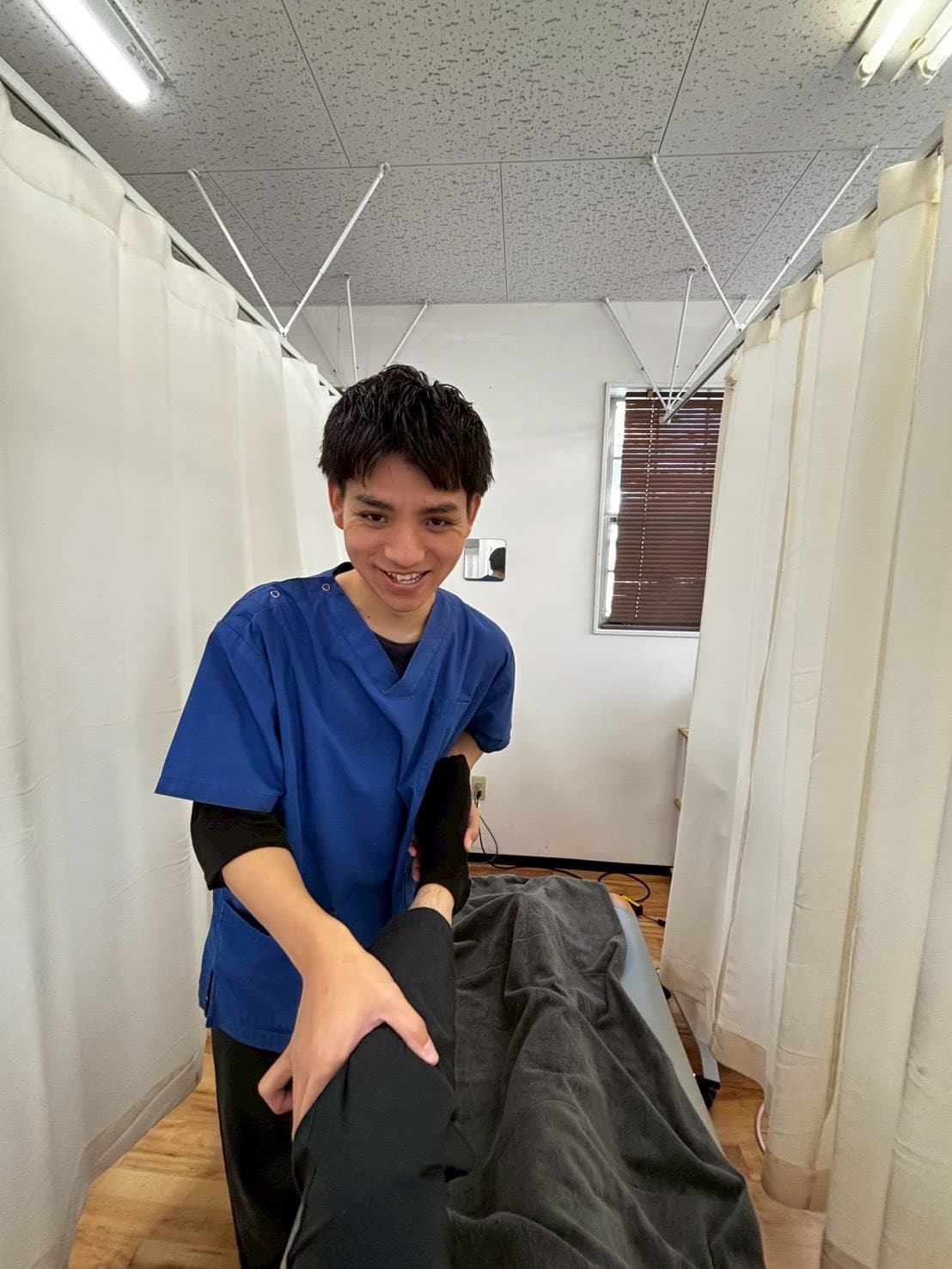 施術風景 - 笑顔で脚の施術